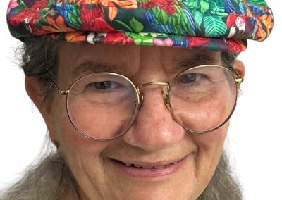 Becky Rawls-Riley wearing a handcrafted ivy flat cap from the Folies line in a custom macaw print designed by Ronya Lake and printed via Spoonflower.