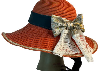 Floppy hat band combining botanical print fabric with lace and performance material accents.