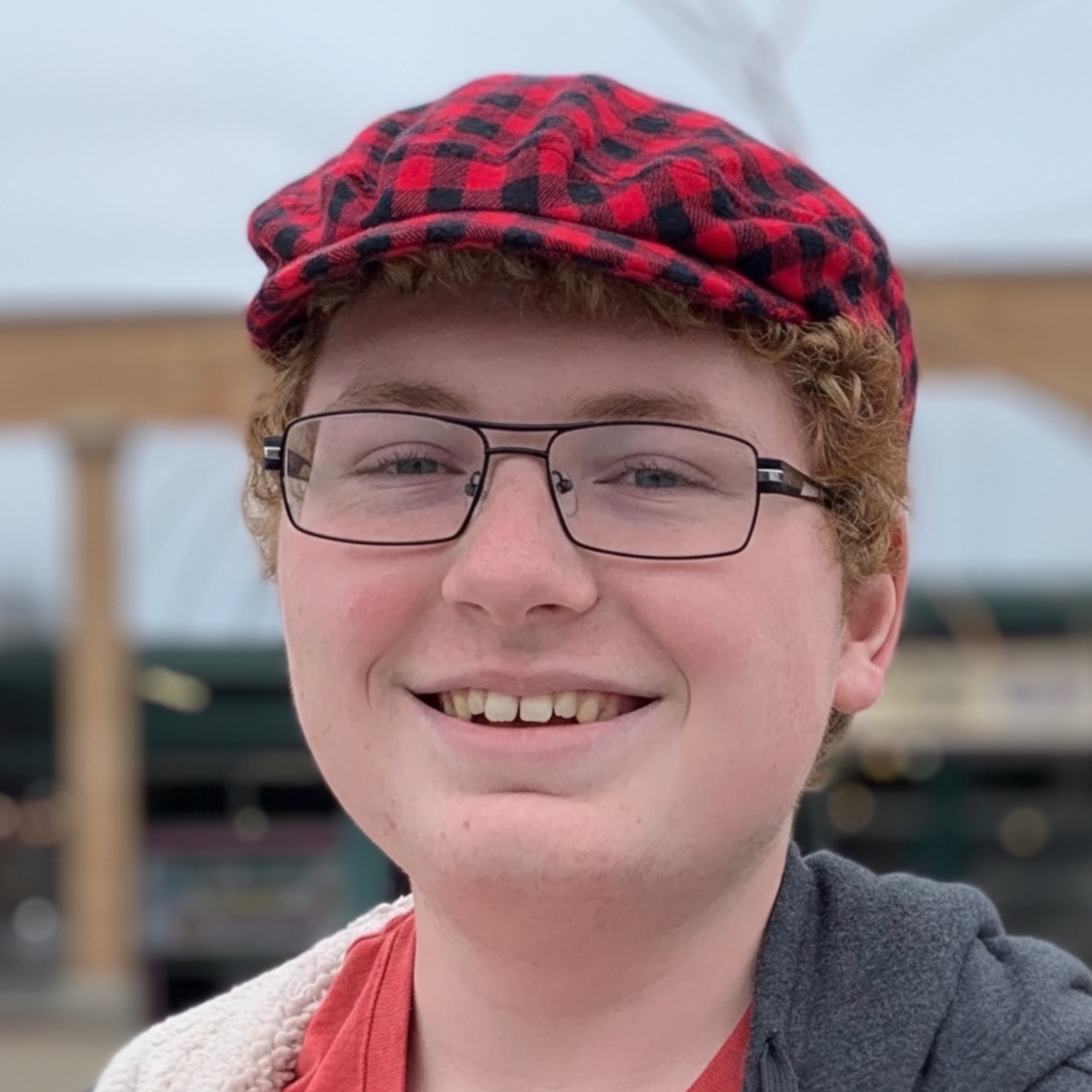 Teen wearing a red and black buffalo plaid flannel ivy flat cap showing close fit and classic style