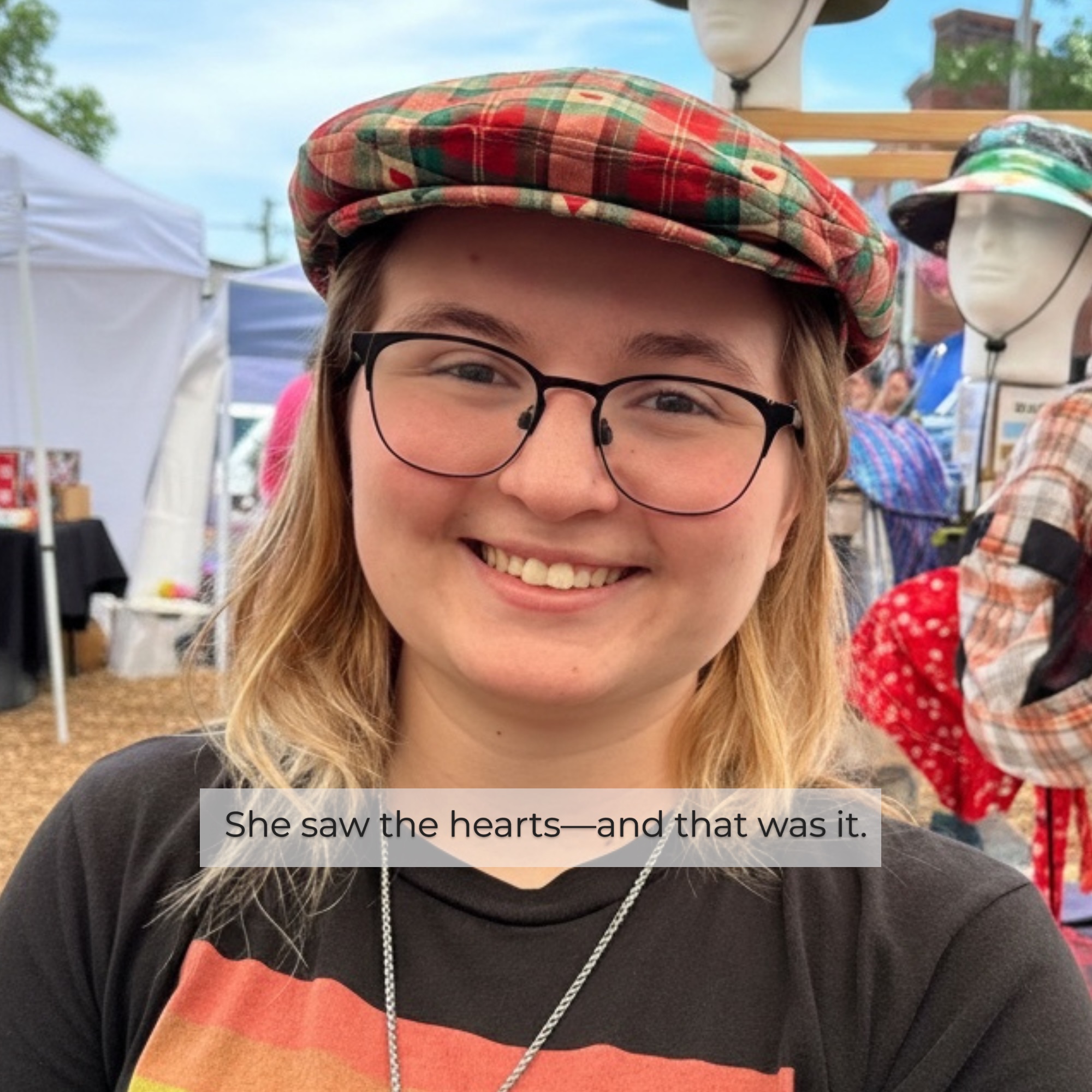 Woman smiling in heart pattern ivy flat cap at outdoor festival