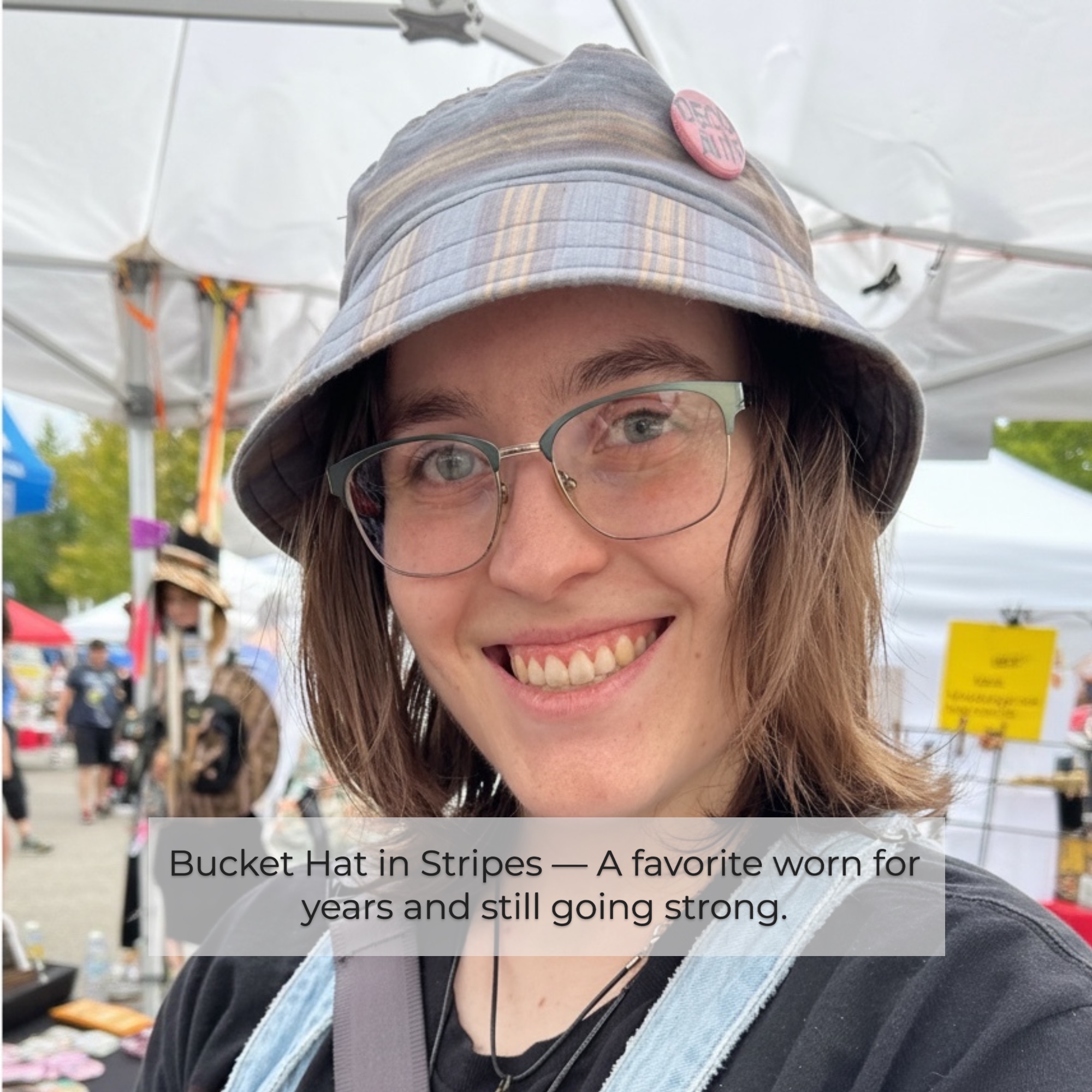 Striped Bucket Hat – Worn and Loved Woman wearing a striped bucket hat at a street festival, a favorite worn for years.